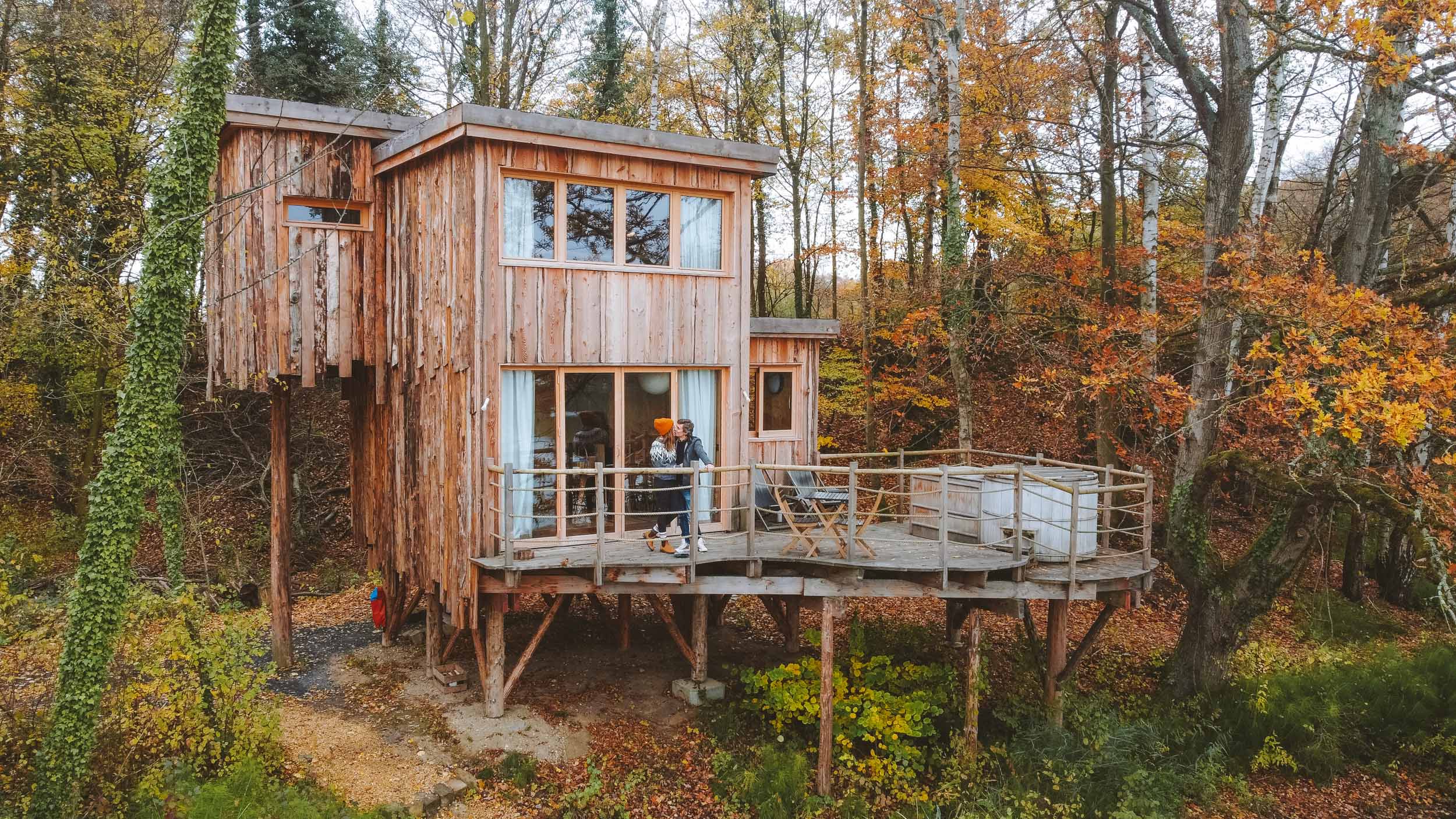 florian and kelly kissing on the terrace of their coucoo cabanes cabin