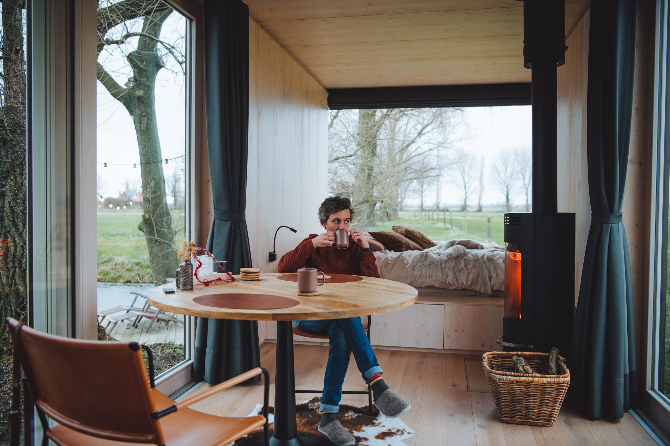 florian drinking tea while sitting at the table next to the fire stove